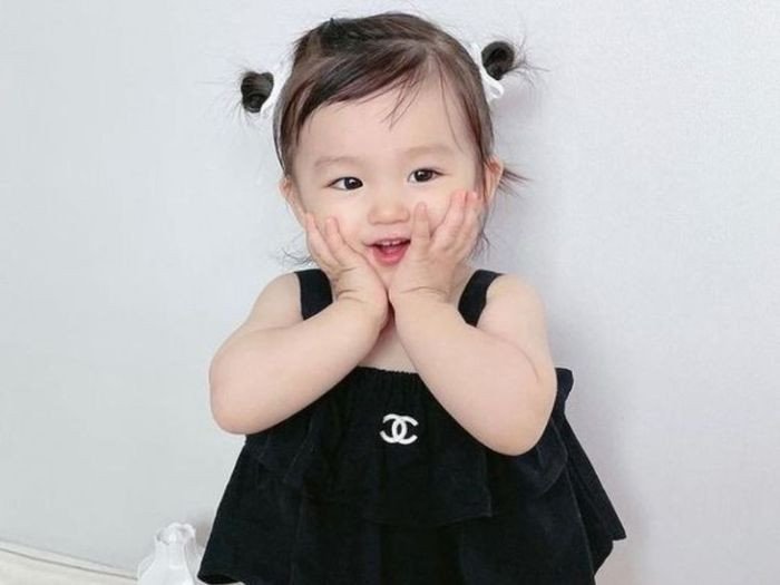 Bé gái ngồi cạnh những viên đá quý lấp lánh, tượng trưng cho sự quý giá và độc đáo