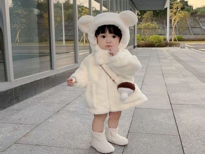 Bé gái với vẻ ngoài đáng yêu và nụ cười tươi, tượng trưng cho vẻ đẹp ngoại hình