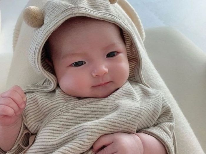 Bé gái với vòng hoa trên tóc, ánh mắt ngước nhìn lên, thể hiện sự thanh khiết và tâm linh