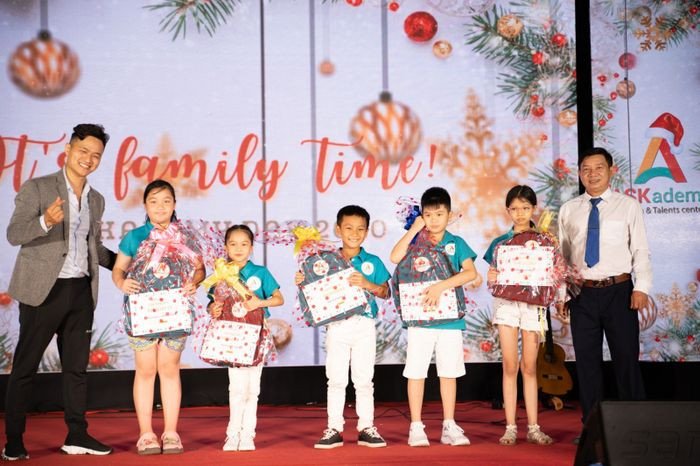 Các em nhỏ đang ngồi trong lớp học, tham gia hoạt động tương tác với giáo viên, minh họa phương pháp học tiếng Anh qua trò chơi