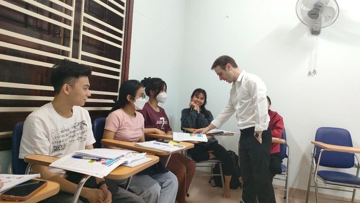 Giáo viên đang giảng bài và tương tác với học viên trong không gian học tiếng Anh hiện đại
