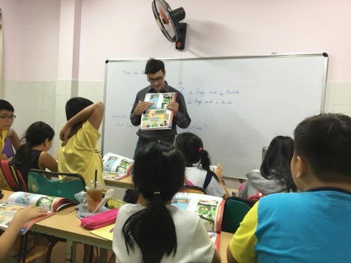 Học viên nước ngoài đang giảng bài trước một nhóm học sinh, minh họa môi trường học tiếng Anh với giáo viên bản xứ