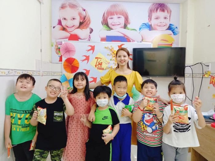 Một giáo viên đang giảng bài cho một nhóm học sinh trong lớp học, tập trung vào phương pháp học tiếng Anh thực hành